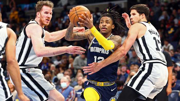 Memphis Grizzles guard Ja Morant (12) drives to the basket as San Antonio Spurs center Jakob Poeltl.